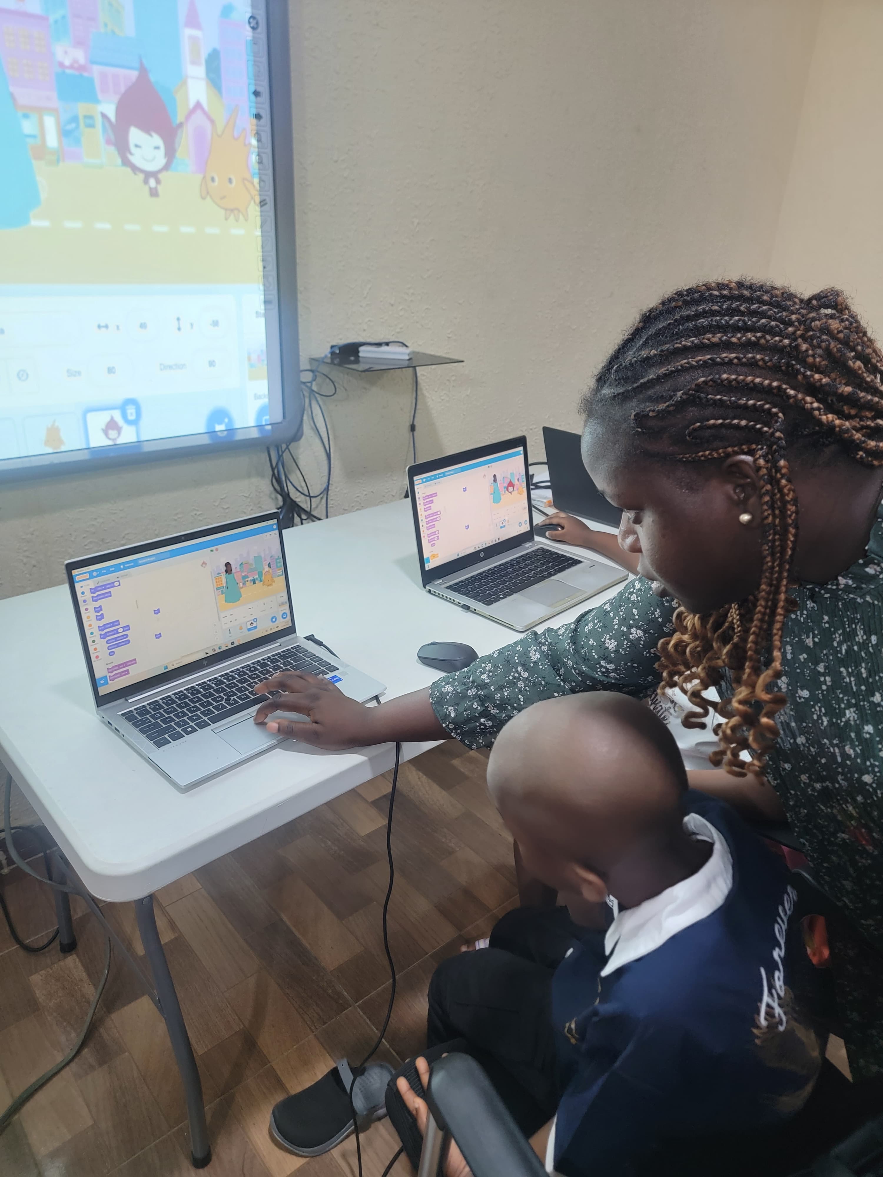 A mentor helping a young learner explore coding at AIR